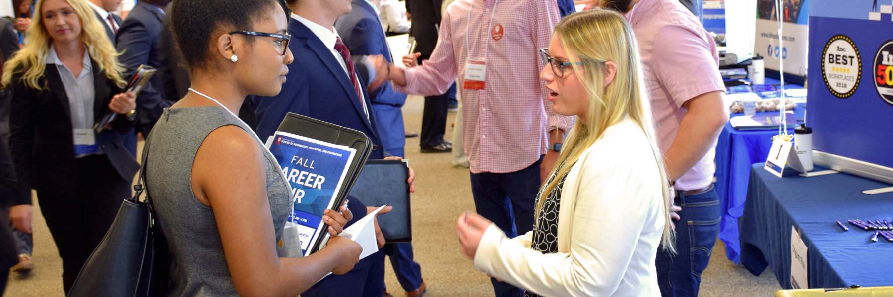 A student talks with a potential employer at a career fair.